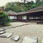 Un patio con jardín zen y casas de estilo oriental, donde el Qi fluye correctamente según el Feng Shui.