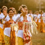 Grupo de ciudadanos balineses vestidos con trajes tradicionales. Sonriendo, saludando y mostrando su espíritu comunitario y de cooperación.