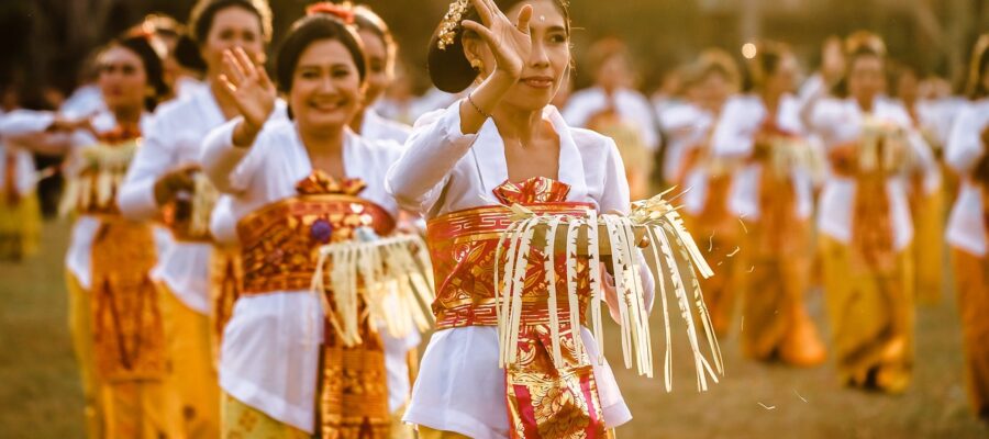 Grupo de ciudadanos balineses vestidos con trajes tradicionales. Sonriendo, saludando y mostrando su espíritu comunitario y de cooperación.