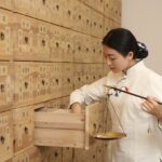 Una mujer joven china trabajando con elementos de la Medicina Tradicional China.