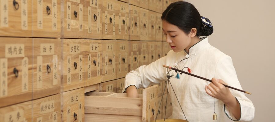 Una mujer joven china trabajando con elementos de la Medicina Tradicional China.