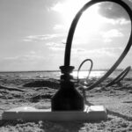 Cable enorme enchufado al suelo de una playa, donde hay un enchufe. Simula la toma a tierra.