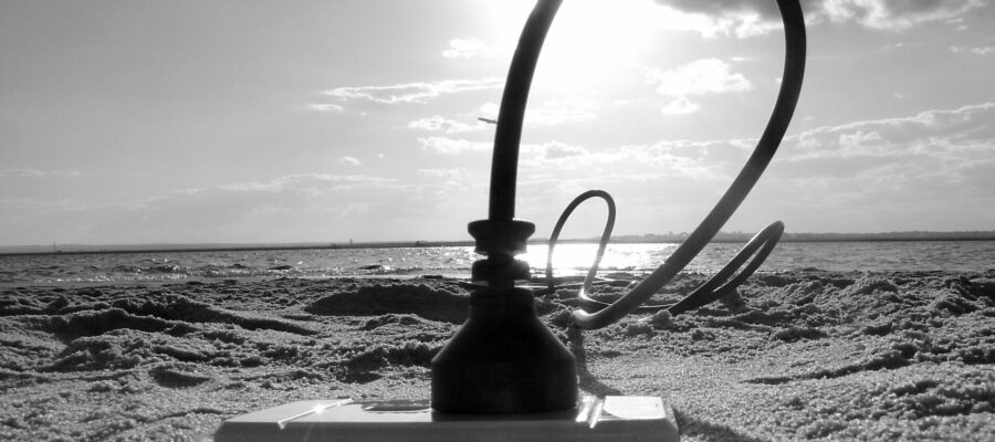 Cable enorme enchufado al suelo de una playa, donde hay un enchufe. Simula la toma a tierra.