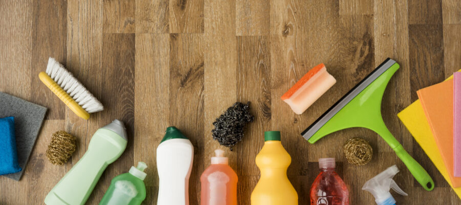 Botellas con productos químicos de limpieza dispuestos sobre una mesa de madera. Muestra de tóxicos que contaminan el aire interior de casa.