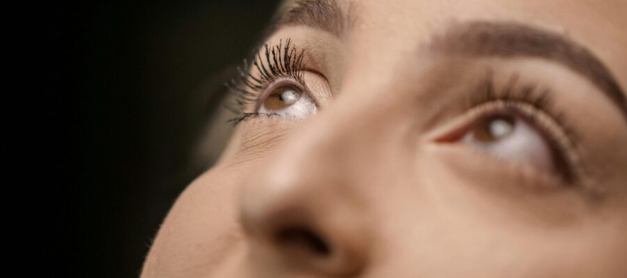 Primer plano de los ojos de una mujer, que mira hacia arriba. Está haciendo ejercicios oculares, siguiendo una meditación.
